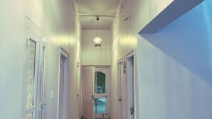 A hallway with a chandelier, doors, and a staircase. - Dormtales Hostel (Varanasi)