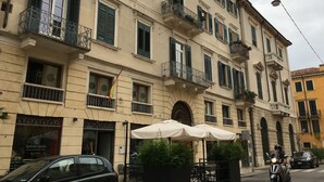 A multi-story building with balconies, outdoor seating, and a restaurant named "Redondo Iglesias." - Aure (Verona)