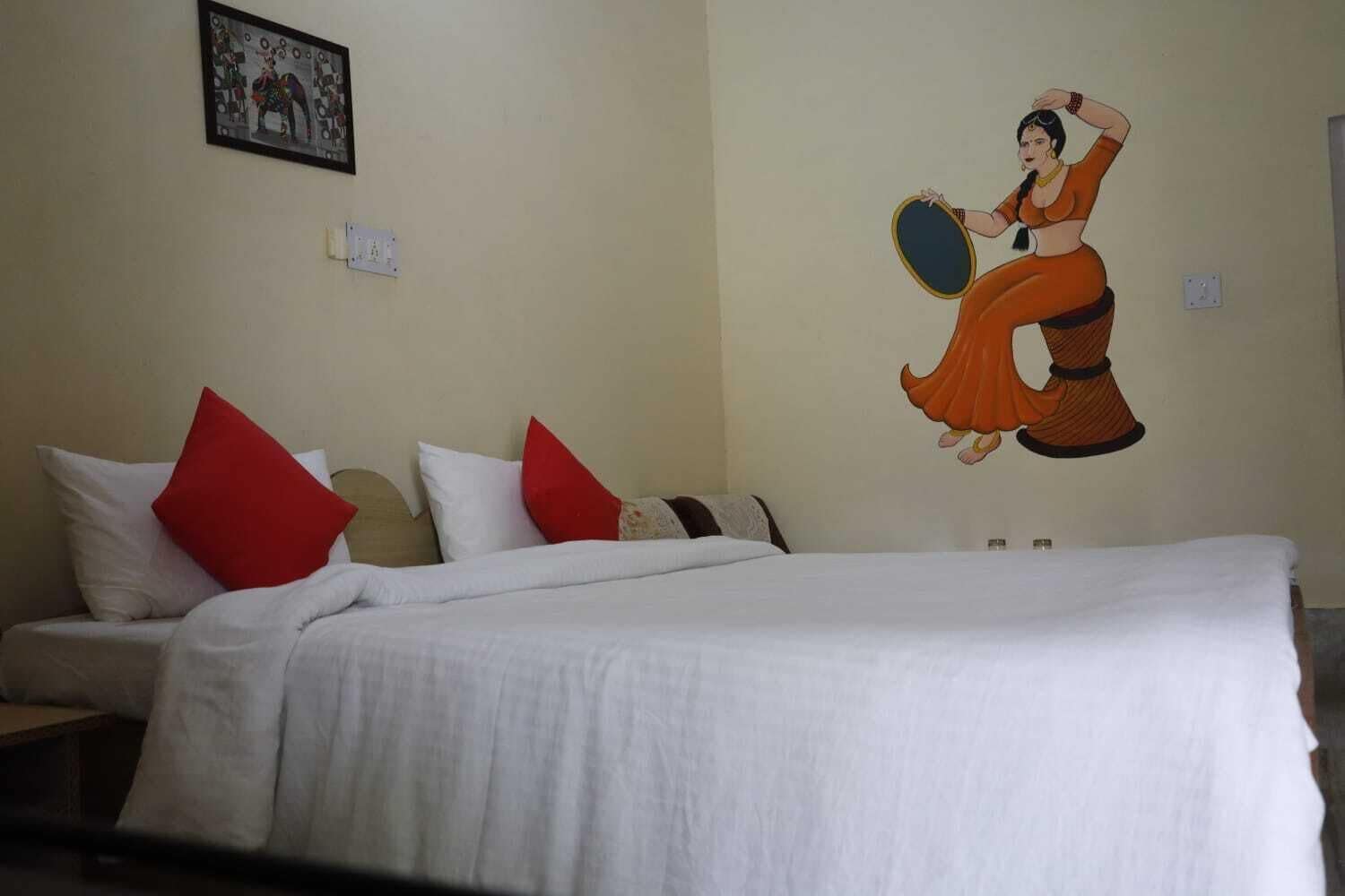 Quarto de hotel com cama, almofadas e um mural na parede.