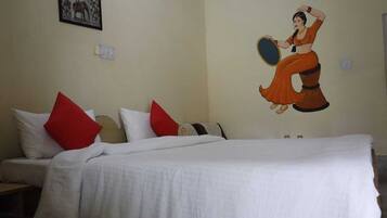 Quarto de hotel com cama, almofadas e um mural na parede.