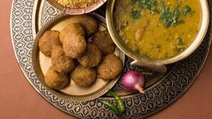 Ein Teller mit einer Suppenschüssel, einer Couscous-Schüssel mit Nüssen und frittierten Bällchen.