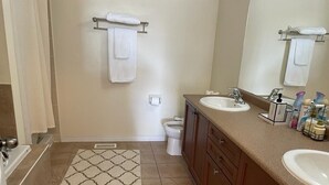 Ein Badezimmer mit einer Badewanne, zwei Waschbecken, einer Toilette und einer Dusche.