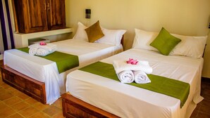 Two twin beds with white linens, green bedspreads, and rolled towels with pink flowers. - Tiara Elephant Lodge (Habarana)