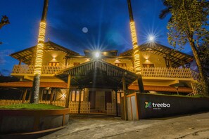 A hotel with a covered entrance, a white picket fence, and a sign reading "treebo River View". - Treebo River View (Madikeri)