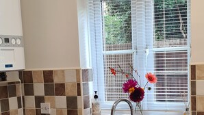 A kitchen with a washing machine, a sink, and a window with blinds. - 3 Bed, Cozy and Comfortable Retreat (Spalding)
