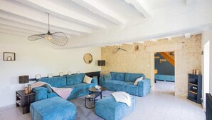 A living room with a sectional sofa, a coffee table, and a hanging light fixture.