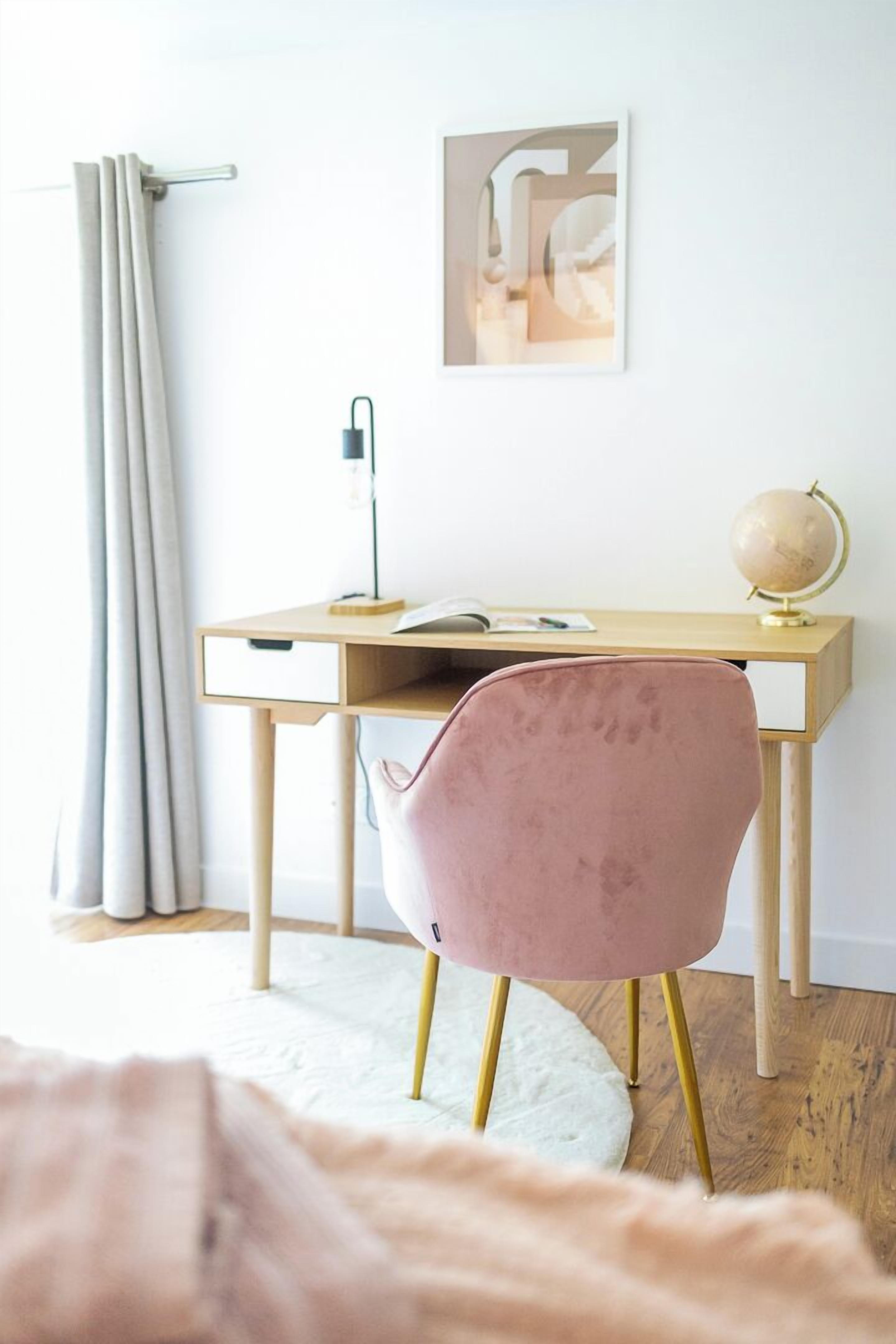 Un espace d’étude comprenant un bureau, une chaise, un globe terrestre et des rideaux.