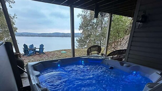 Un bain à remous avec vue sur un lac et des montagnes en arrière-plan.