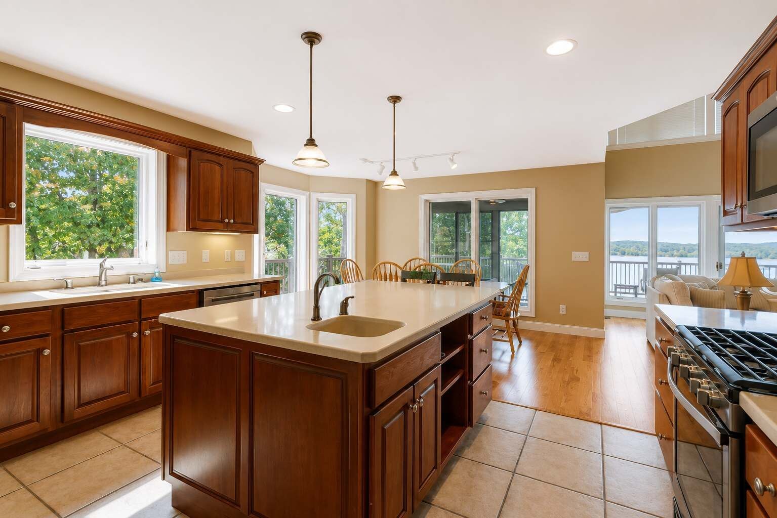 Una cocina amplia con una isla grande, armarios de madera y vistas al exterior.