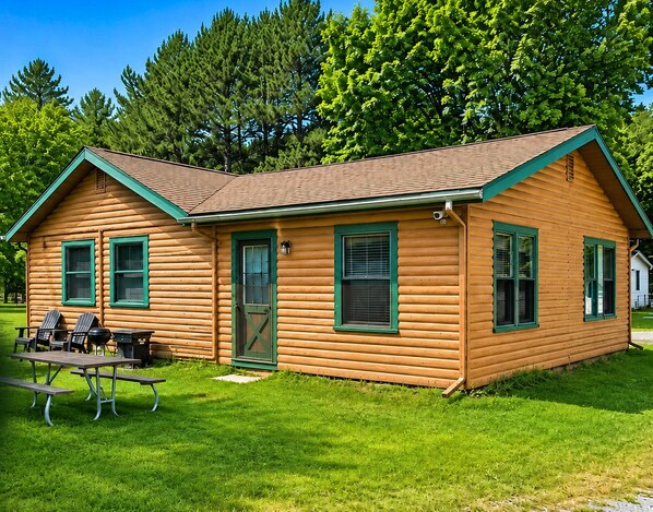 Cozy log cabin retreat with spacious lawn, outdoor seating, and room for 8