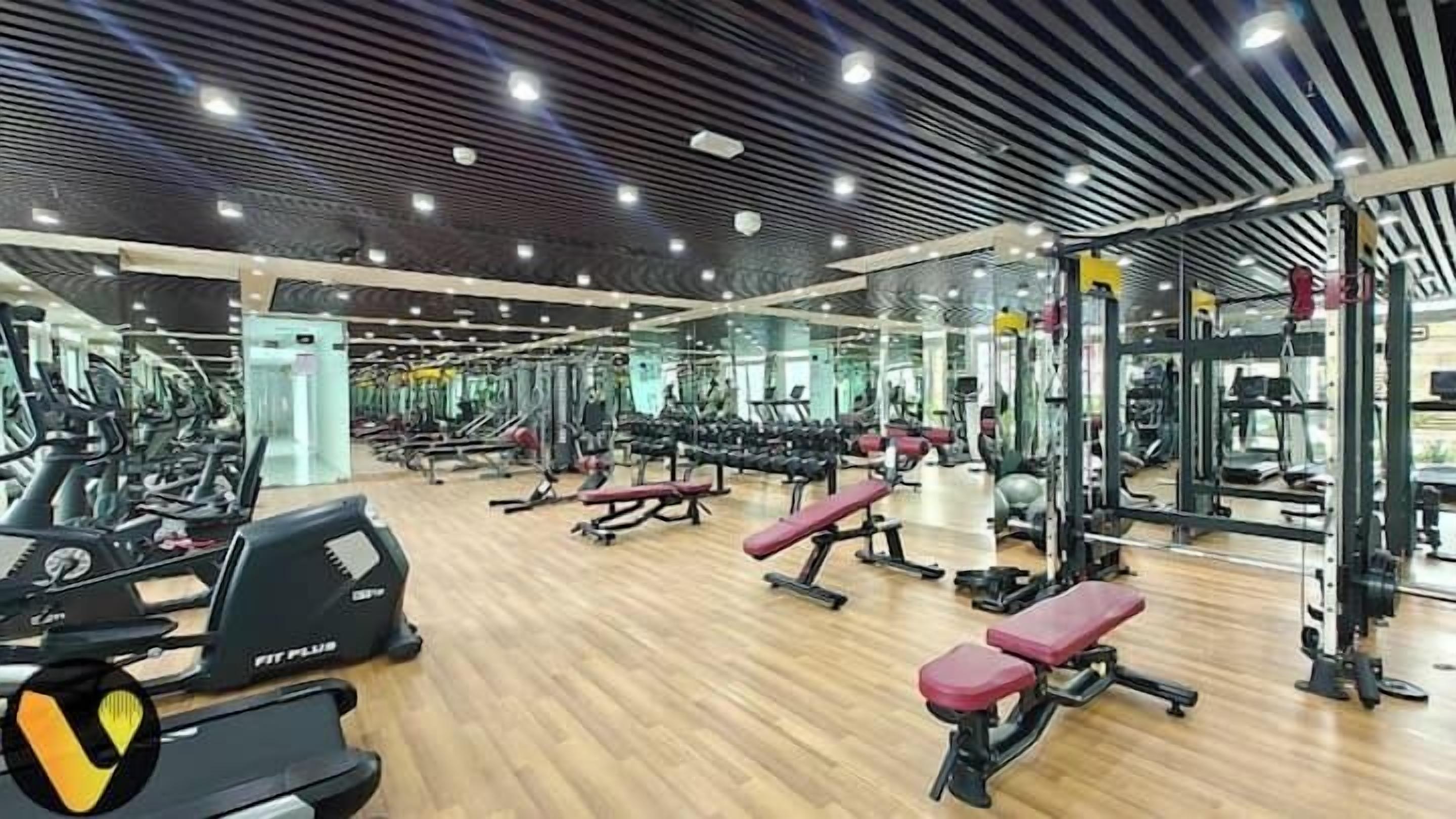 A gym with various exercise equipment, including treadmills, weight machines, and benches.