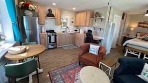Un espacio habitable compacto con kitchenette, comedor y dormitorio.