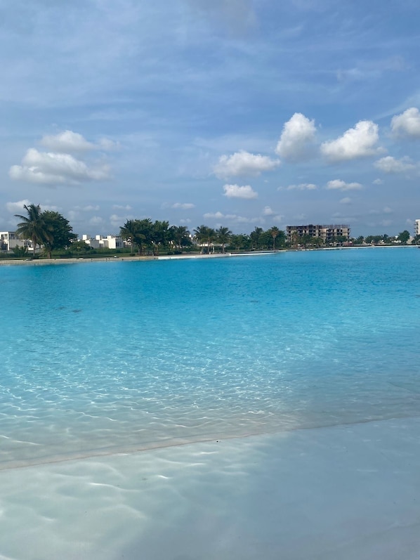 A clear blue sea with a sandy beach and a row of buildings in the background. - Casa de Descanso a 20 Minutos de Lugares Turísticos (Veracruz)