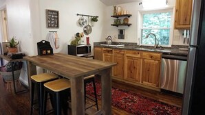 A kitchen with wooden cabinets, a stainless steel refrigerator, a microwave, and a sink. - Cozy cabin in the Cherokee National Forest. (Del Rio)