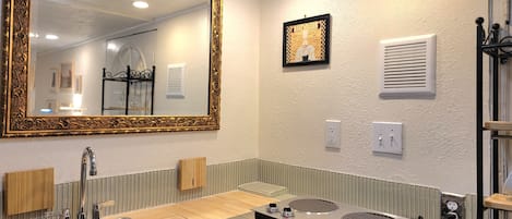 A modern bathroom with a large mirror, a sink, a vanity, and a towel rack.