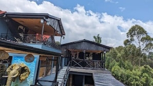 A two-story building with a balcony on the upper floor and a staircase leading to the second floor. - Idembe Heritage (Nyamabuye)