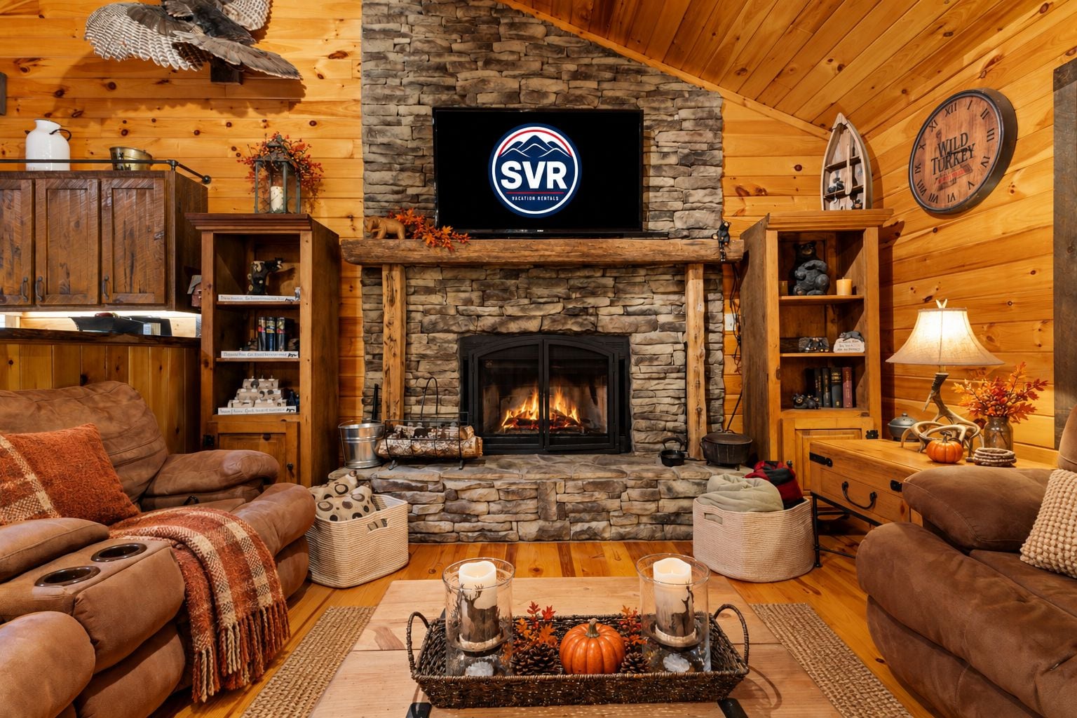 Een knus houten chaletinterieur met een stenen openhaard, houten wanden, een tv aan de muur en een boekenkast.