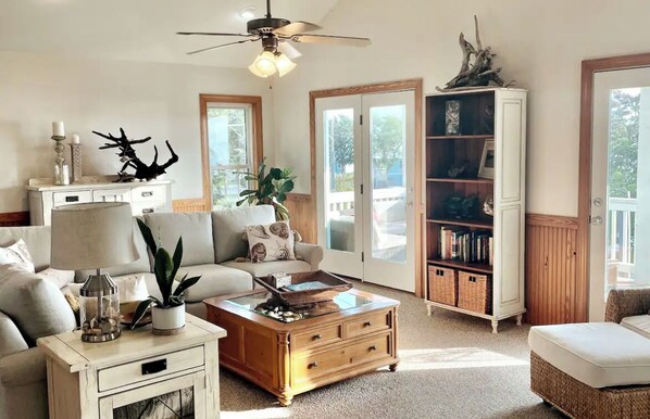 A cozy living room with a sofa, coffee table, and bookshelf.