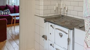 A kitchen with white tiled walls, a stove, and a door with a handle. - 2 bedroom nice home in Mariannelund (Mariannelund)