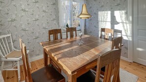 A dining room with a wooden table and chairs, a chandelier, and floral wallpaper. - 2 bedroom nice home in Mariannelund (Mariannelund)
