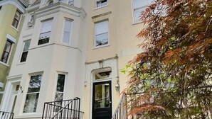 A multi-story building with a central entrance and a staircase leading to the ground floor. - Perfect Adams Morgan Location! Charming & Historic (Washington)