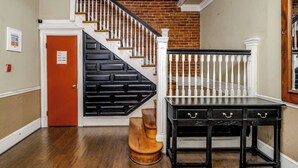 A staircase with white balusters and a black railing, a wooden bench, and a black table with drawers. - Perfect Adams Morgan Location! Charming & Historic (Washington)