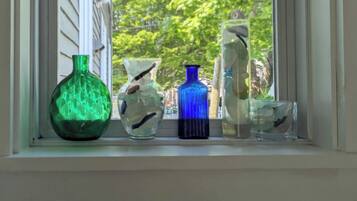 A window with various glass objects on the sill.