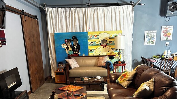 A cozy living room with a sofa, a leather armchair, a coffee table, and a television. - Cozy studio in enjoyable Gypsum with AC, WiFi (Gypsum)