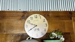 A welcome sign for The Blue Possum Lodge, a clock, a pot, and a checkered mug on a shelf. - Cozy studio in enjoyable Gypsum with AC, WiFi (Gypsum)