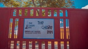 Une enseigne indiquant l’emplacement du Chobe Inn, avec les coordonnées et le numéro de parcelle.