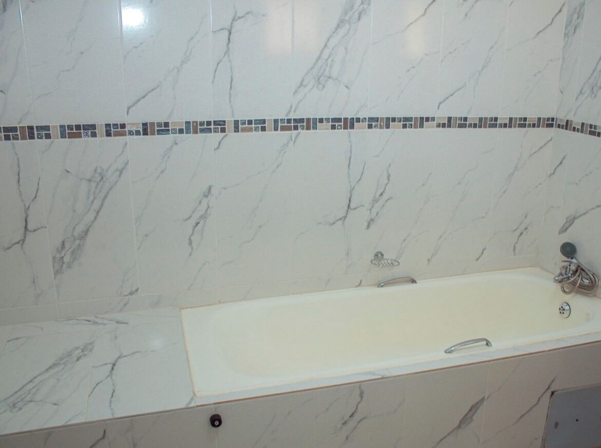 A bathroom with a marble sink and a shower.