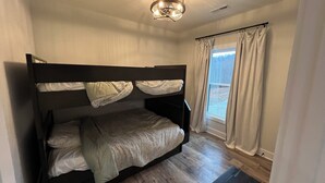 A bunk bed room with a window, curtains, and a ceiling light fixture. - Secluded New Cottage, Minutes From Sunset Marina Overlooking Pendergrass Creek (Byrdstown)