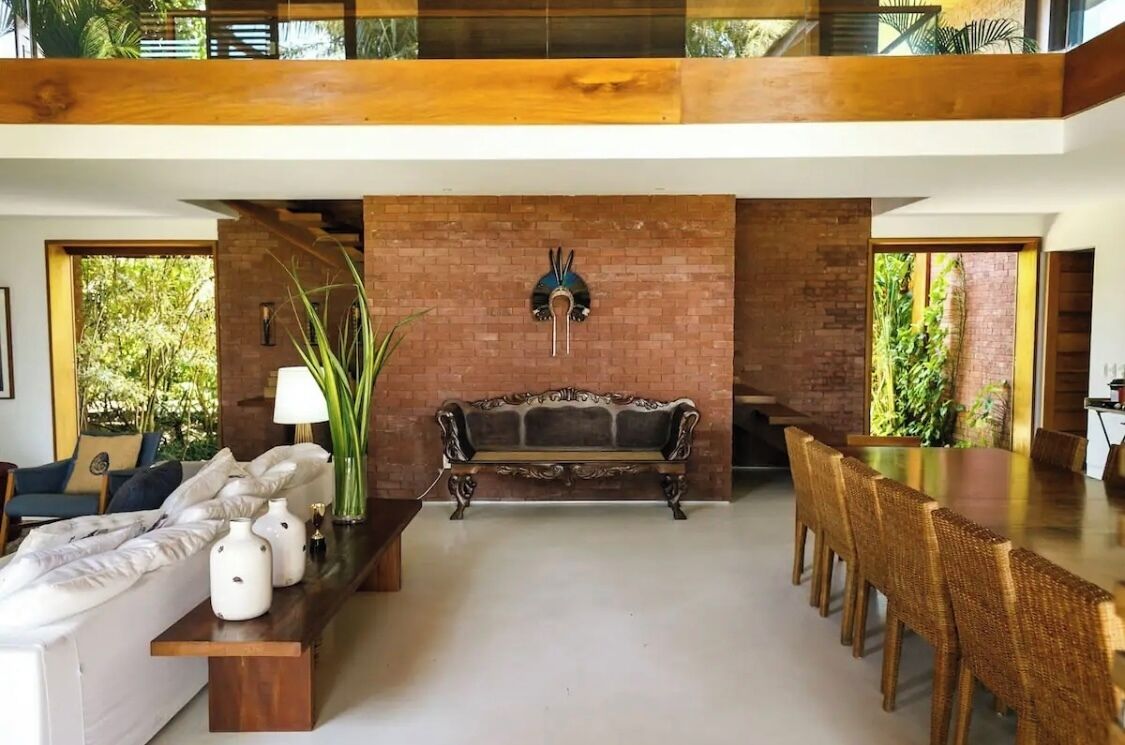 A modern living room with a sofa, coffee table, and a dining area with chairs.