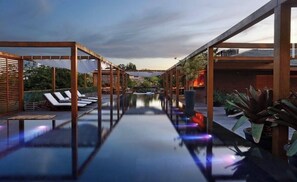 A rooftop pool area with sun loungers and a clear view of the city skyline. - Terravista Villa Safira Trancoso (Porto Seguro)