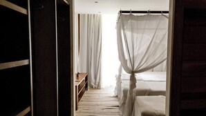 Ein Schlafzimmer mit Himmelsbett, einer Holzbank und einem Streifen Teppich.
