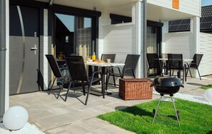 Enjoy dining and socializing in this outdoor space, featuring a round table and comfortable seating for six.