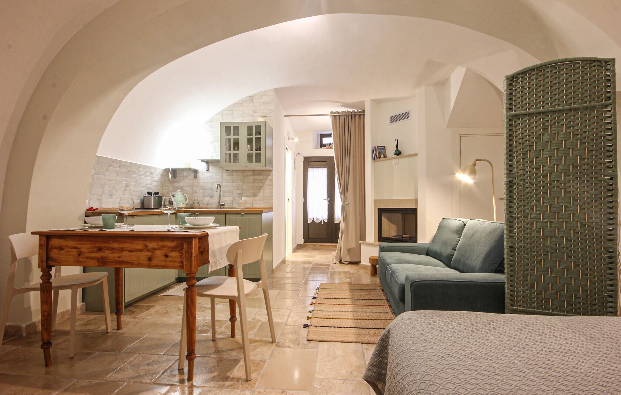 Ein gemütliches Wohnzimmer mit einer Couch, einem Esstisch mit Stühlen und einer Küche im Hintergrund.