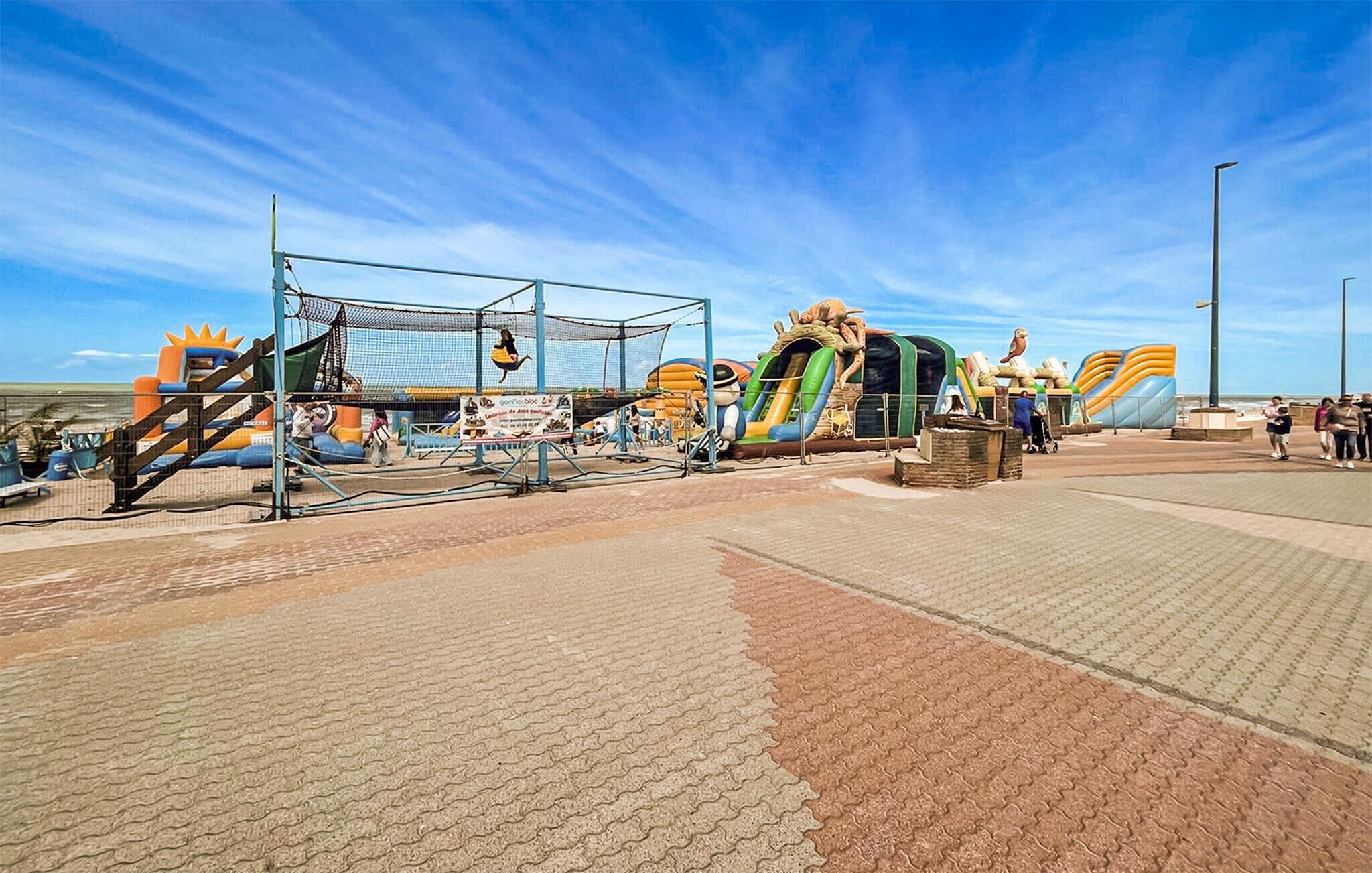 An outdoor amusement park with various rides and play structures.
