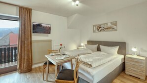 Une chambre d’hôtel avec un lit, une table de chevet, une chaise et une vue sur l’extérieur.