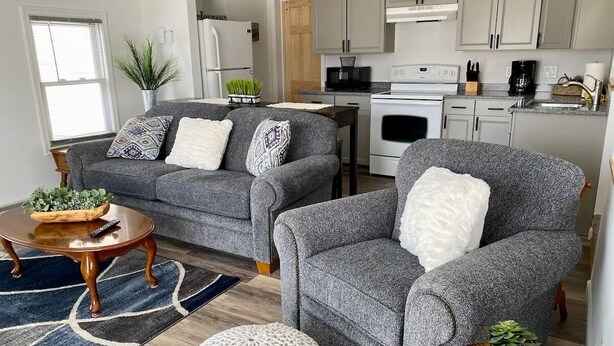 A modern living room with grey sofas, a wooden coffee table, and a round ottoman. - Cozy, Clean & Convenient 1-bedroom apartment with AC & WiFi in charming Clayton (Clayton)