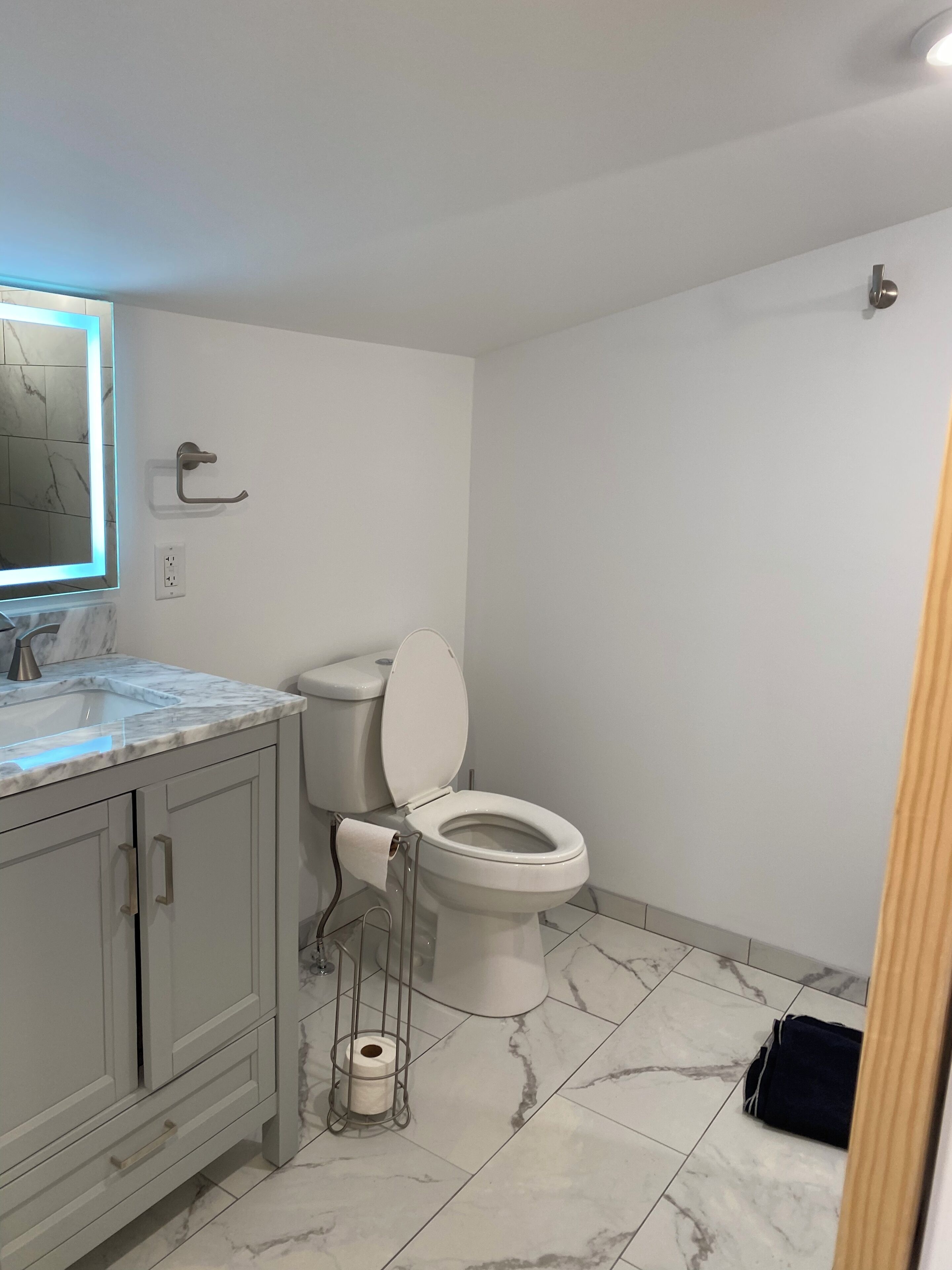 Ein Badezimmer mit Toilette, Waschbecken und Bodenfliesen aus Marmor.