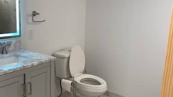 Ein Badezimmer mit Toilette, Waschbecken und Bodenfliesen aus Marmor.