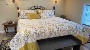 A bedroom with a bed, bedside tables, a nightstand, a bench, and a window with blinds. - Cozy, Clean & Convenient 1-bedroom apartment with AC & WiFi in charming Clayton (Clayton)