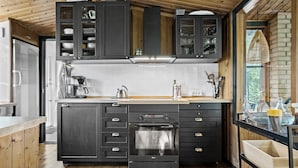 A modern kitchen with dark cabinetry, a built-in oven, and a coffee maker. - Nice home in Gørlev with WiFi (Gørlev)