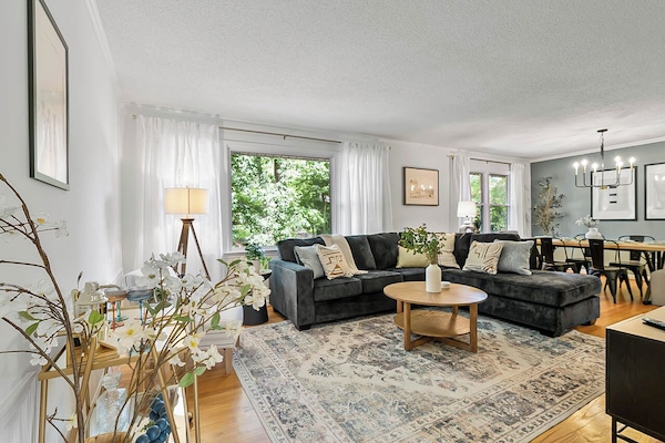 Large living room with cozy lounges and a view of the dining area at the far end