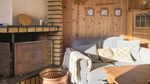 Une pièce chaleureuse avec une cheminée, un canapé et un meuble en bois.
