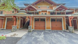 A large, multi-story building with a prominent entrance, multiple garage doors, and a staircase leading to the upper levels.