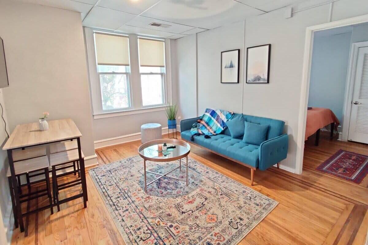 A modern living room with a blue sofa, a coffee table, and a rug.