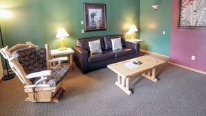 A furnished living room with a sofa, two armchairs, a coffee table, and two lamps. - Mountain style one bedroom with fireplace (Estes Park)
