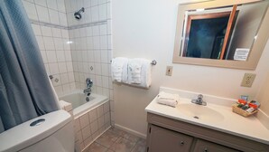 Ein Badezimmer mit Toilette, Badewanne, Waschbecken und Spiegel.